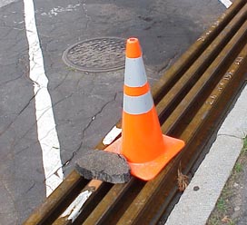 Rock on cone on rails on blacktop next to tracks